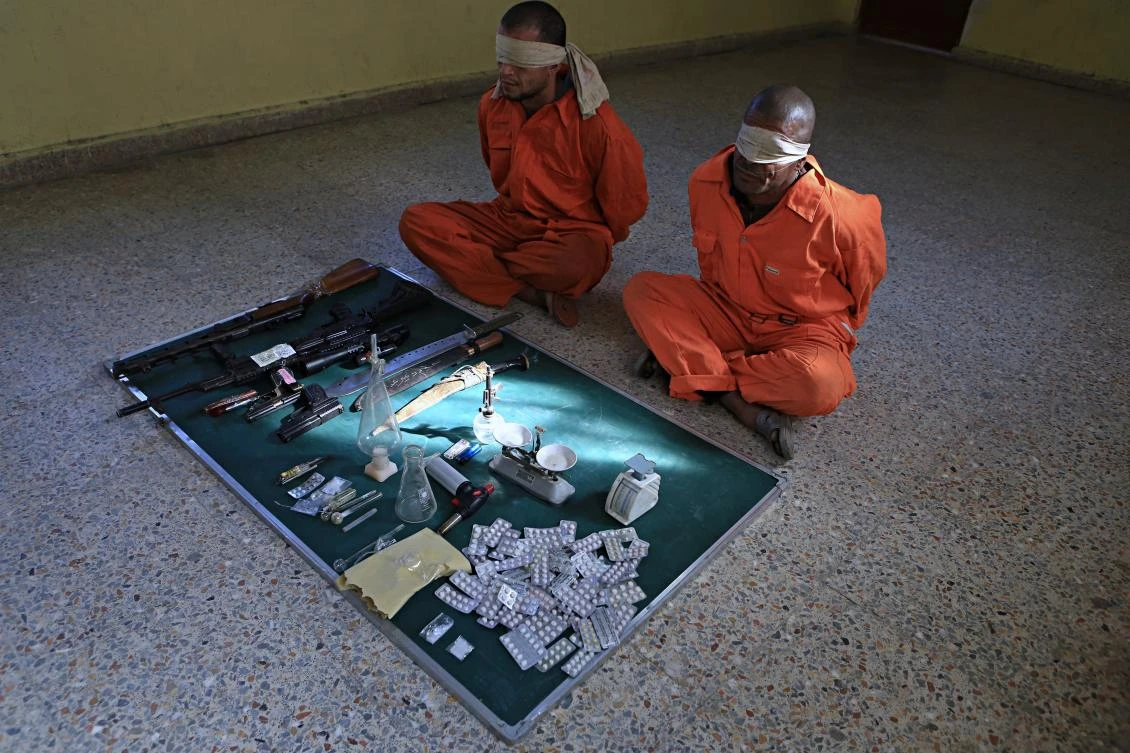 In this Tuesday, Dec. 5, 2017 photo, blindfolded suspected drug dealers are displayed with their goods and weapons in a detention facility in Basra, 340 miles (550 kilometers) southeast of Baghdad, Iraq. In Iraq’s southern Basra province, illegal drug use and trade are hitting unseen levels, mainly among youth, taking the lead in a nationwide spike that has transformed Iraq from merely a corridor for drug trafficking to neighboring countries. Officials blame the country’s porous borders, a widespread ban on alcohol and poverty for the increase. (AP/Nabil Al-Jurani)