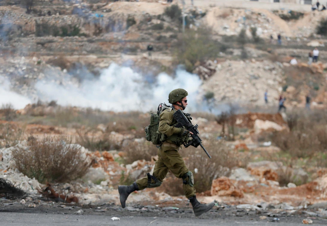 An Israeli soldier runs during a protest against US President Donald Trump’s decision to recognize Jerusalem as the capital of Israel, near the Jewish settlement of Beit El, near the West Bank city of Ramallah Dec. 21, 2017. (Reuters/Goran Tomasevic)