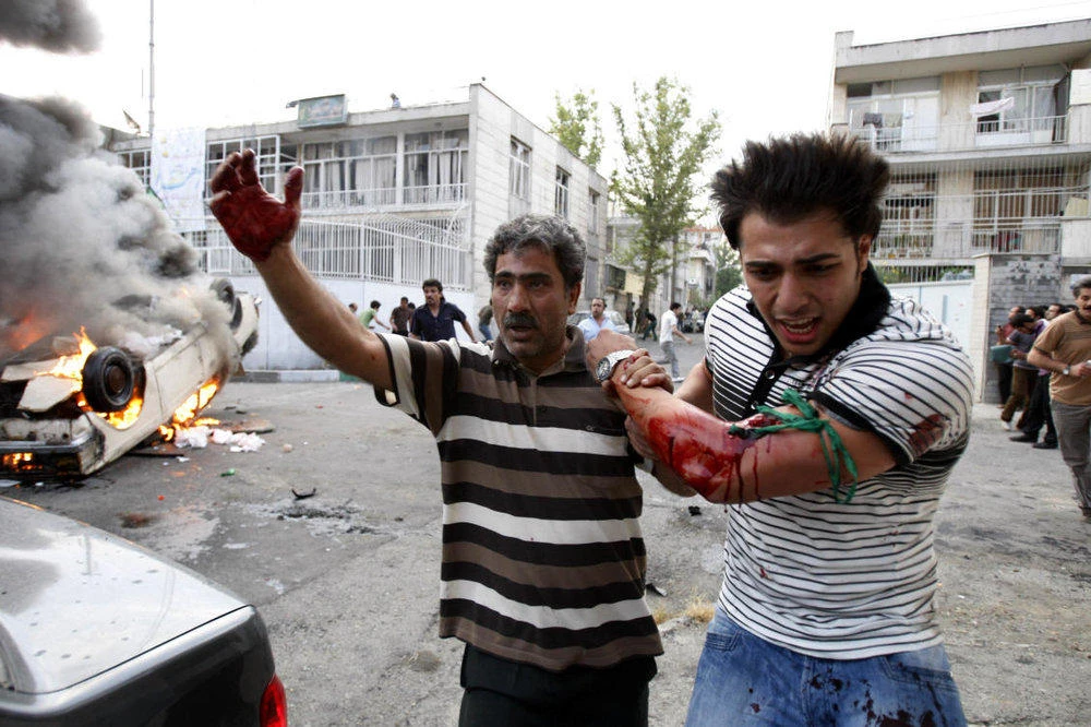 In this June 15, 2009 file photo, a protester allegedly injured by gunfire from pro-government militia is helped by another protester near a rally supporting leading opposition presidential candidate Mir Hossein Mousavi in Tehran, Iran. Nearly nine years ago, massive crowds marched through the streets of Iran’s capital and other cities demanding change in the first major unrest to shake the rule of hard-line Muslim clerics. Now Iran’s Islamic Republic is seeing a new, equally startling wave of unrest. This time it appears to be fueled by anger over a still faltering economy, unemployment and corruption. (AP)
