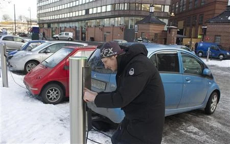 A Norwegian citizen disconnects his electric car from a free recharging station in Oslo. Pure electric cars and hybrids, which have both battery power and a diesel or petrol motor, accounted for 52 percent of all new car sales in Norway last year. (Reuters)