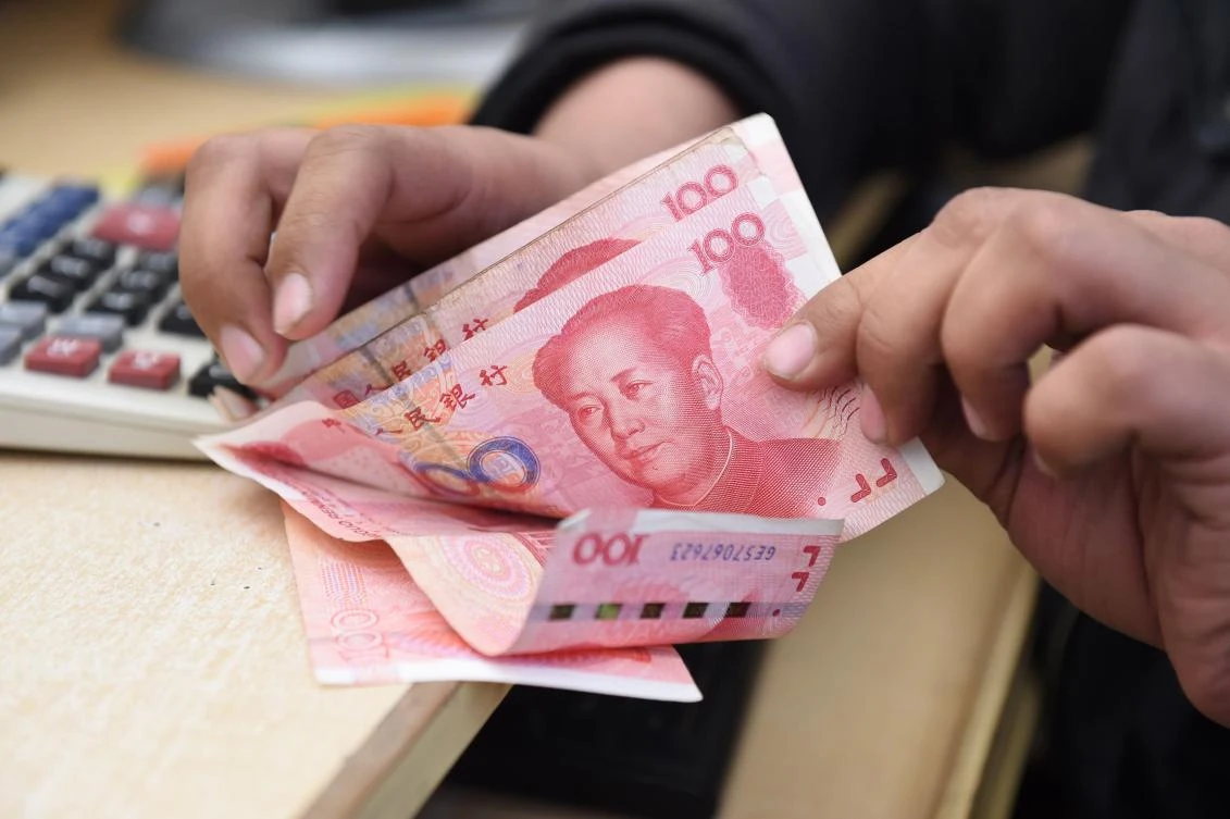 A Pakistani currency dealer counts Chinese currency for a customer in Quetta. Pakistan will allow the Chinese yuan to be used for imports, exports and financing transactions for bilateral trade and investment activities, in a move economists said would simplify a massive Chinese investment project. (AFP)