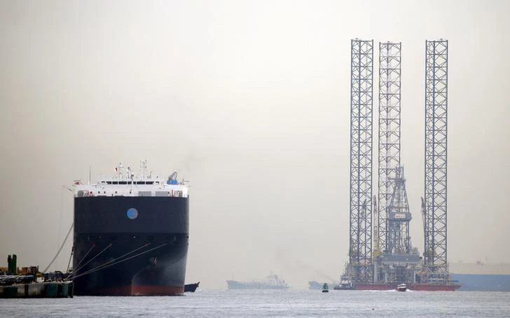 Global investment in exploration will be 7 percent lower to $37 billion this year, over 60 percent below the 2014 peak, according to WoodMac. Above, an offshore drilling platform is towed past a car carrier docked at Singapore port in this November 2015 photo. (Reuters)