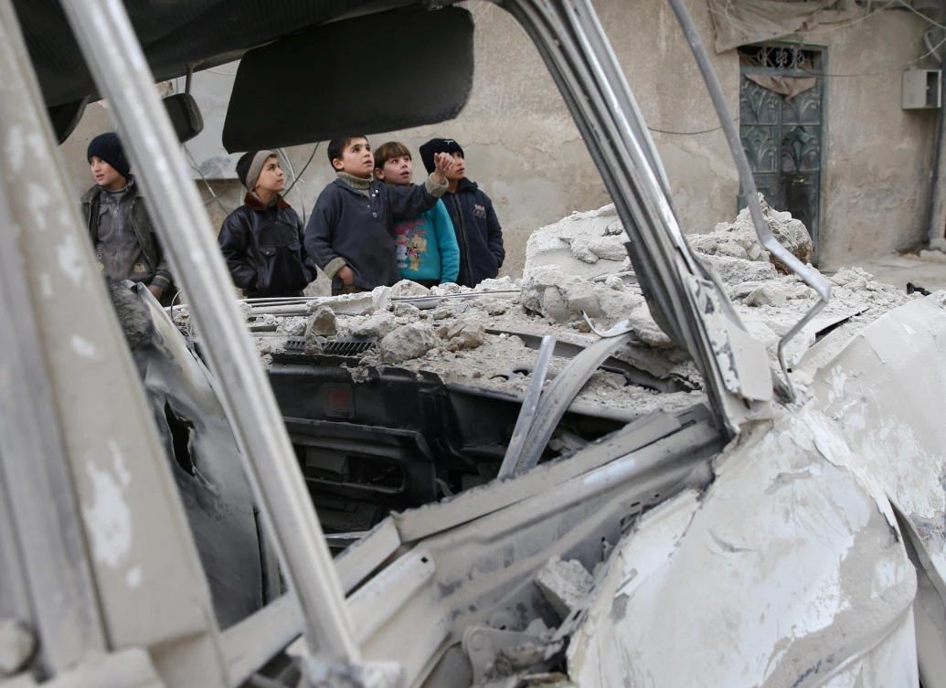 Boys stands near a damaged site after an airstrike on the Eastern Ghouta town of Misraba, Syria. (Reuters)