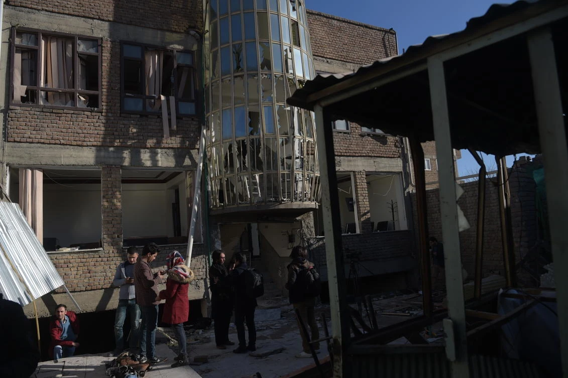 A suicide attacker blew himself up near a crowd of police and protesters in Kabul, killing at least 11 people and wounding 25 others. In this photo, Afghan residents walk at the site of a bomb attack on a cultural center in Kabul on December 28, 2017. (AFP)