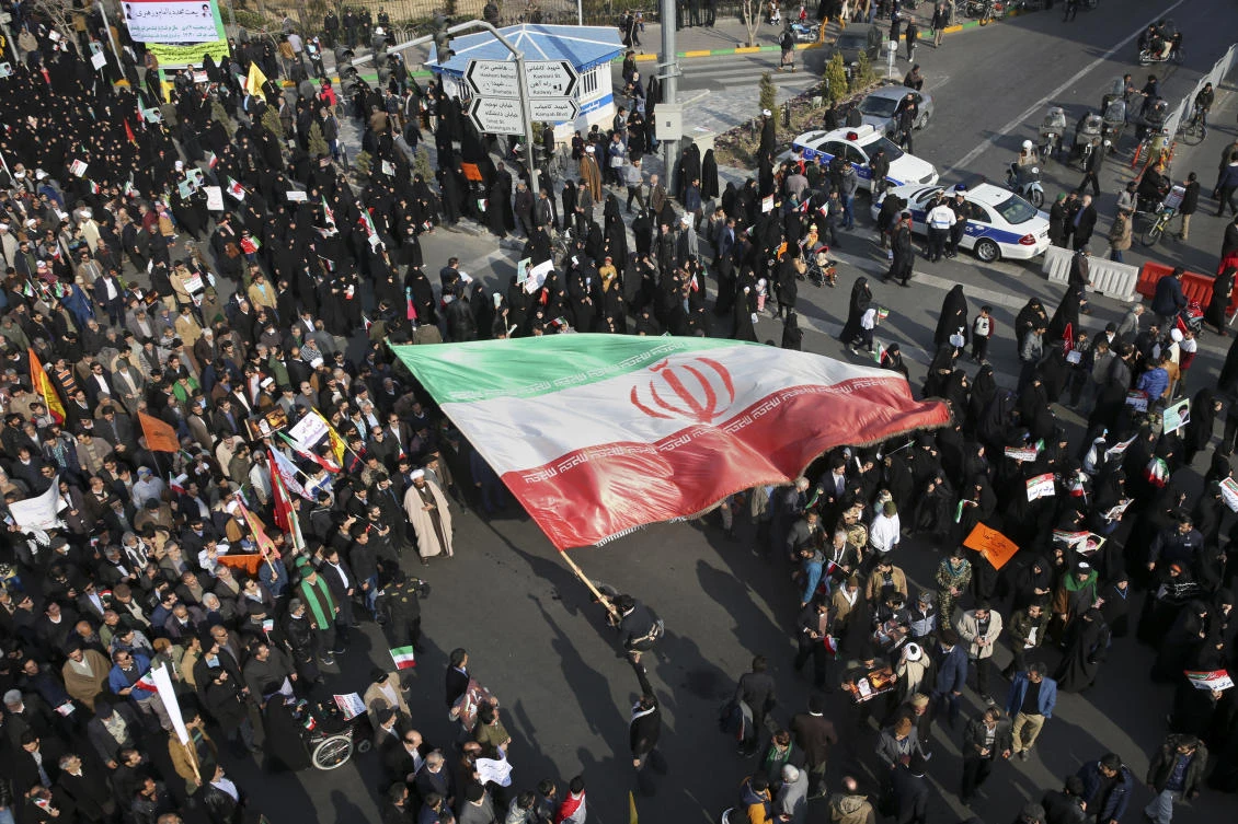 US says can hold Iran responsible for violence against protesters. In this photo provided by Tasnim News Agency, a demonstrator waves a huge Iranian flag during a pro-government rally in the northeastern city of Mashhad, Iran, Thursday, Jan. 4, 2018. (AP)