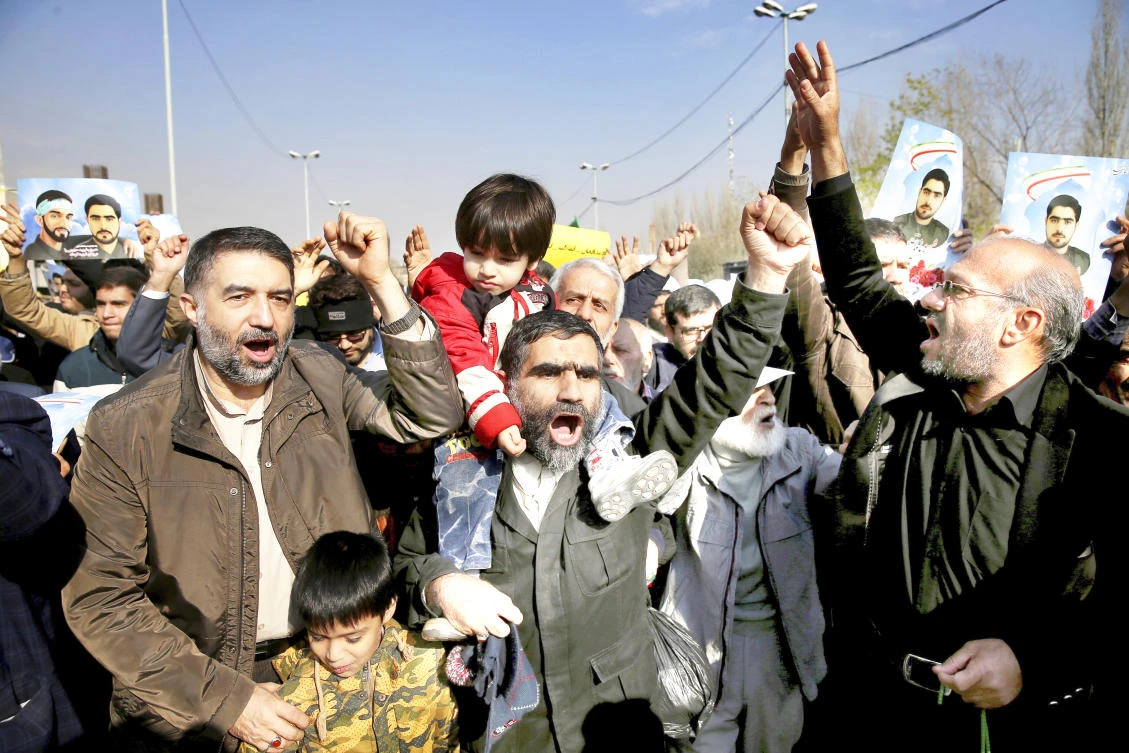 Iranians chant slogans during a rally against anti-regime protestors in Tehran on Friday. (AP)