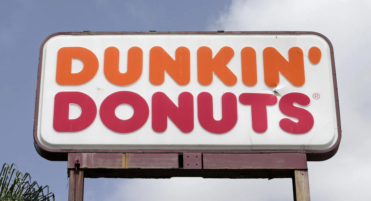 A Dunkin’ Donuts sign at a store in Hialeah, Florida Dunkin’ Donuts is cutting back on its food and drink offerings. The Boston Herald reports the new, simplified menu is expected to roll out in New England locations starting Monday, Jan. 8, 2018, before expanding nationwide in mid-March. (AP/Alan Diaz, File)