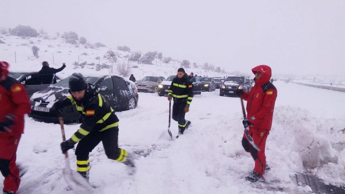 Personnel from the Spanish army’s emergency unit UME working to unblock cars stuck on the AP6 highway after a heavy snowfall. (AFP)