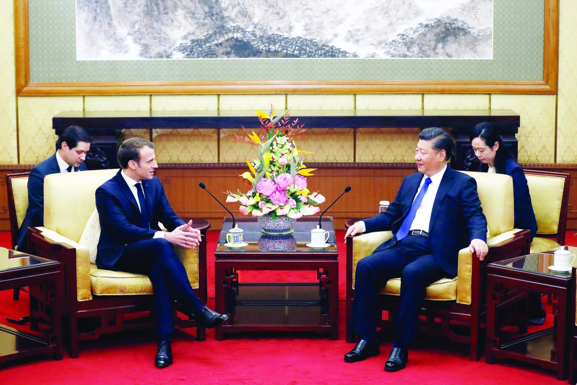 French President Emmanuel Macron, second left, chats with Chinese President Xi Jinping during a meeting at the Diaoyutai State Guesthouse in Beijing on Monday. (AFP)