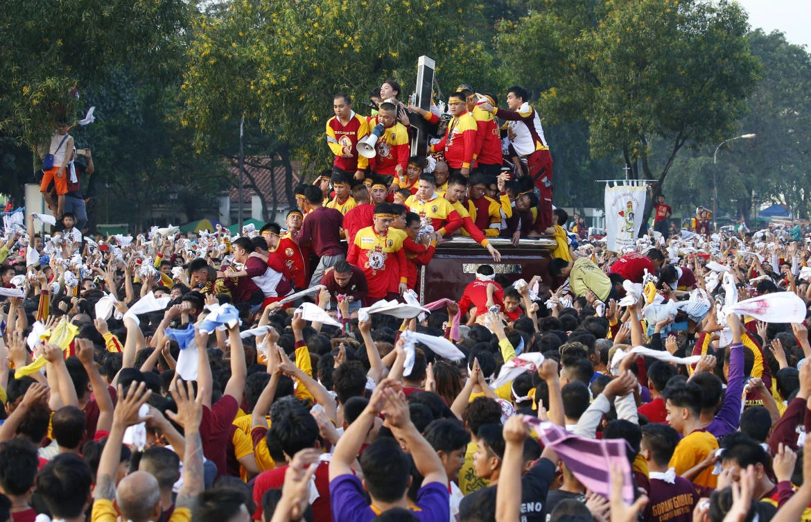 Filipino Roman Catholic devotees wave towels as they jostle to get closer and kiss the image of the Black Nazarene in a raucous procession to celebrate its feast day January 9 in Manila. (AP)