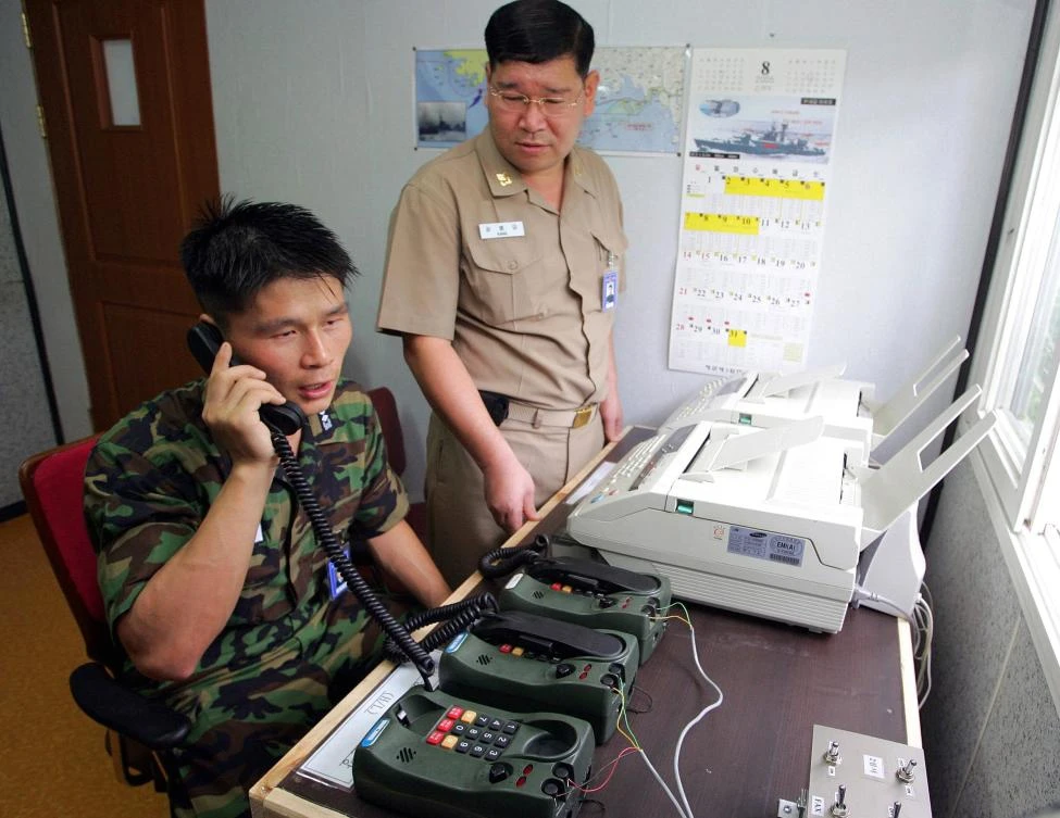 Above, South Korean Lieutenant Choi Don-Rim, left, communicates with a North Korean officer during this December 10, 2005 phone call at a military office near the Demilitarized Zone which separates North and South Korea. (AFP)