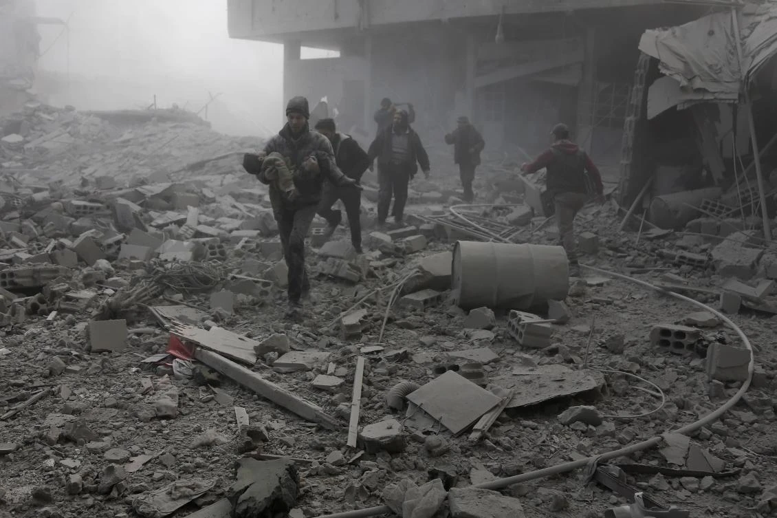 Syrian Civil Defense carries an infant out of the rubble following an air strike in the besieged rebel-held Eastern Ghouta area near Damascus. (AFP)