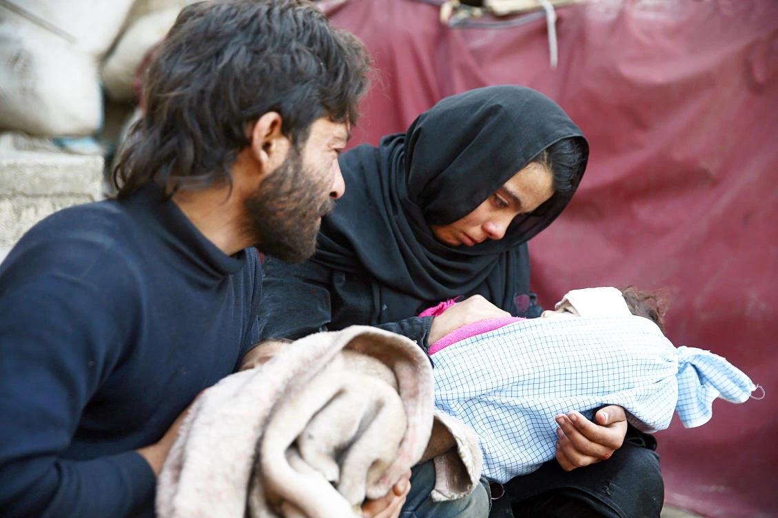 Heba Amouri holds the body of her two-year-old son, Emir Al-Bash, at a medical center in the besieged town of Douma, Eastern Ghouta, Syria. (Reuters)