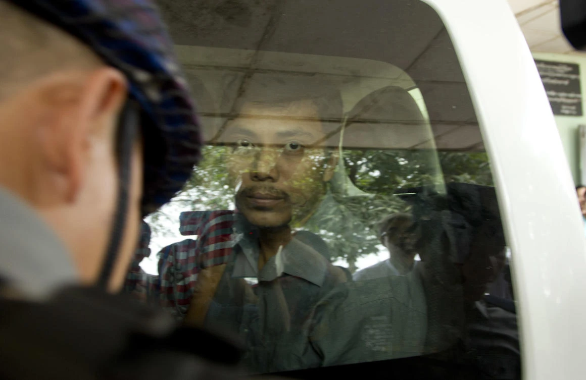 Reuters journalist Kyaw Soe Oo, also known as Moe Aung, looks out from a police van after a court appearance, last December 27, 2017, outside Yangon. (AP)