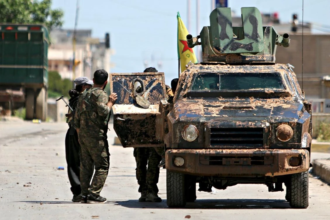 Kurdish fighters from the People's Protection Units (YPG) stand near a military vehilce in the southeast of Qamishli city, Syria, in April 2016. (Reuters)