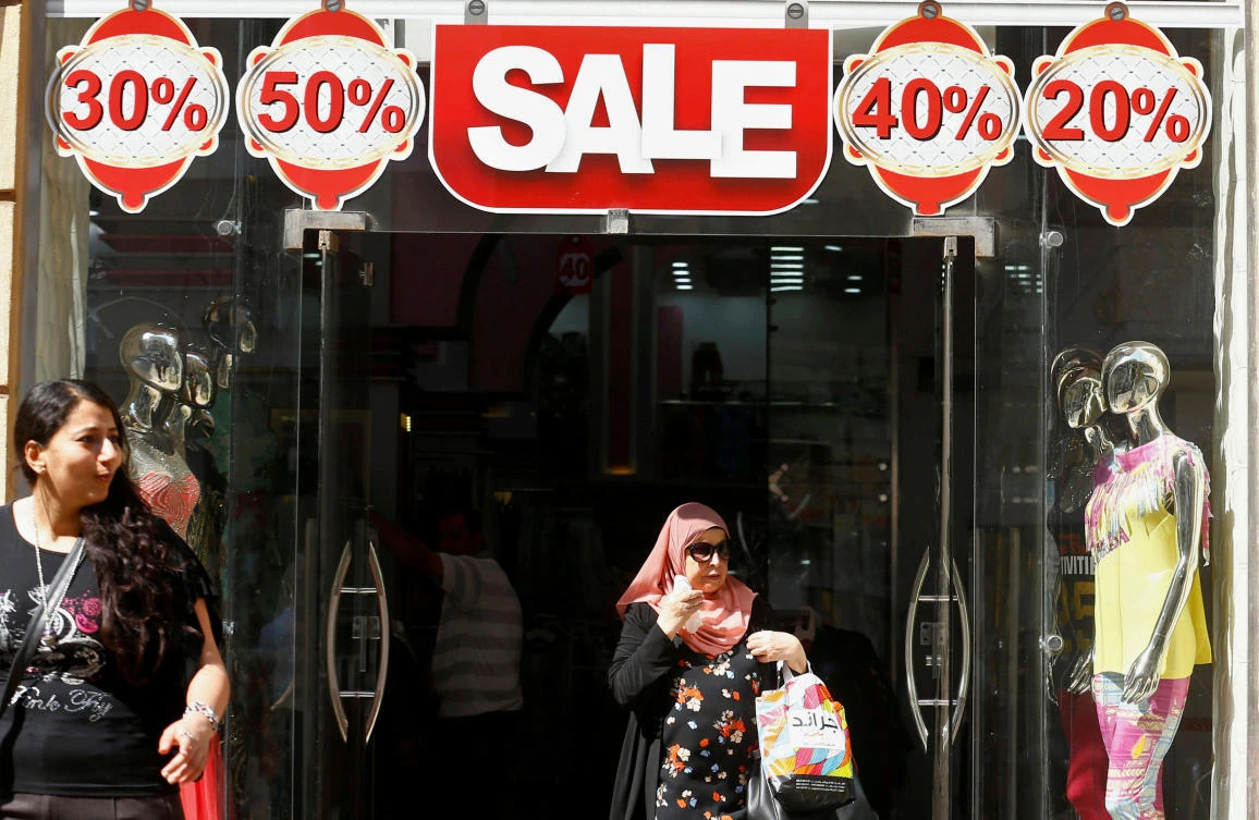 Woman leaves a clothing shop showing items for sale in Cairo, Egypt. The country's inflation dropped sharply in December. (Reuters)