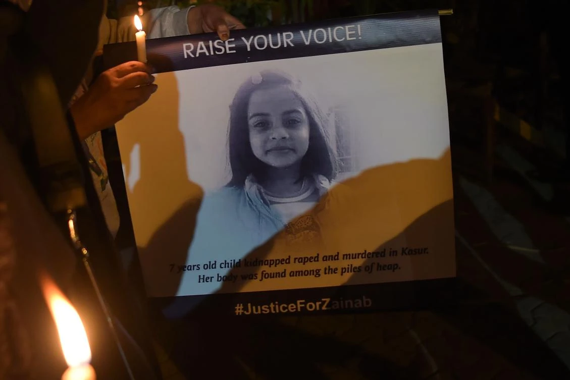 Pakistani civil society activists hold candles and placard with an image of Zainab, who was raped and murdered in the city of Kasur in Punjab province, in Islamabad on January 11, 2018 during a vigil in tribute to the child. (AFP)