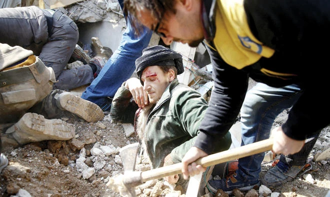 Abu Abdallah is being pulled out from under the rubble following an airstrike in Saqba, Eastern Ghouta, Syria. (Reuters)