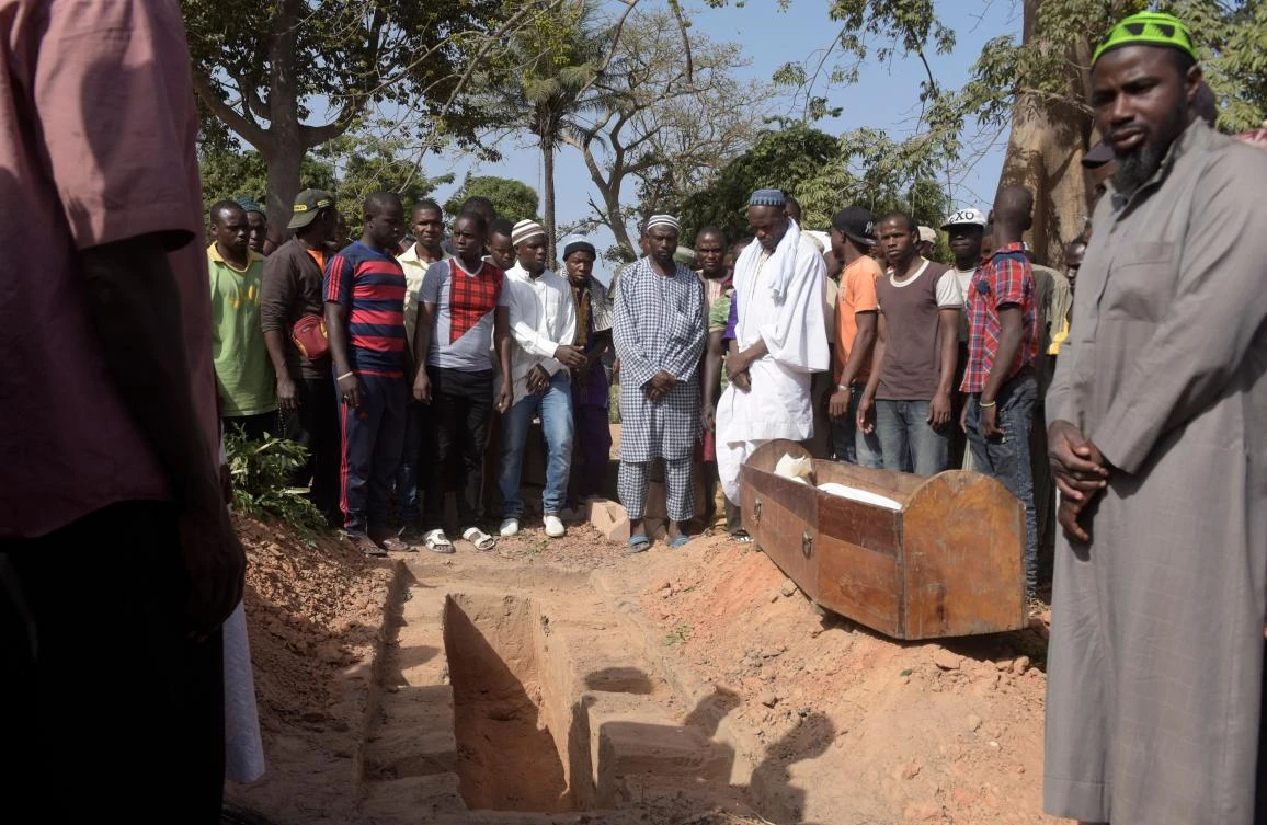 Men pray next to a coffin during a burial in a cemetery in the regional capital Ziguinchor, southern Senegal following an attack by armed men in the Bayotte forest. (AFP)
