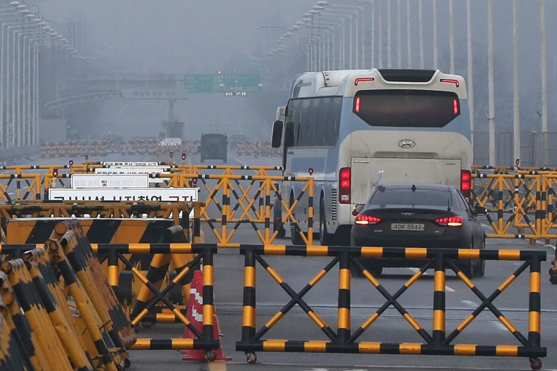 A bus carrying a delegation of South Korean officials passes a military checkpoint on the road leading to the border truce village of Panmunjom, as they begin further talks with their North Korean counterparts regarding next month’s Winter Olympics. (AFP)