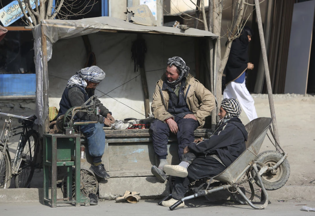 An elderly cobbler man, left, repairs a shoe on the outskirts of Kabul, Afghanistan, Tuesday, Jan. 9, 2018. (AP)