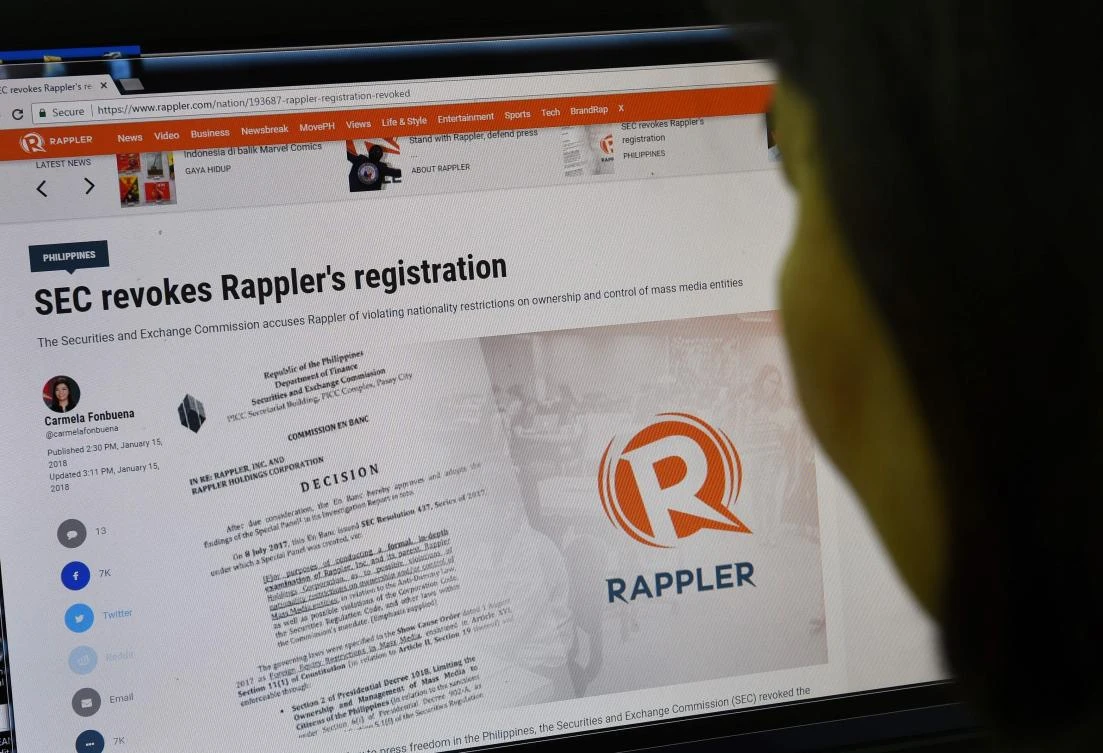 This photo illustration shows a woman reading the website of online newsportal Rappler, which the Philippine government has revoked the operating license of, in a ruling denounced by President Rodrigo Duterte's critics as another blow to press freedom in the country. (AFP)