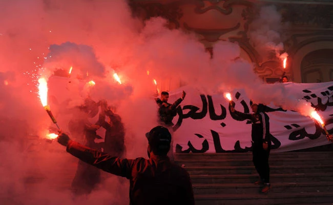 Tunisian protesters carry flares and shout slogans during celebrations in central Tunis on January 14, 2018, marking the seventh anniversary since the uprising that ousted ex-president Zine El Abidine Ben Ali and launched the Arab Spring. (AFP / ANIS MILI)
