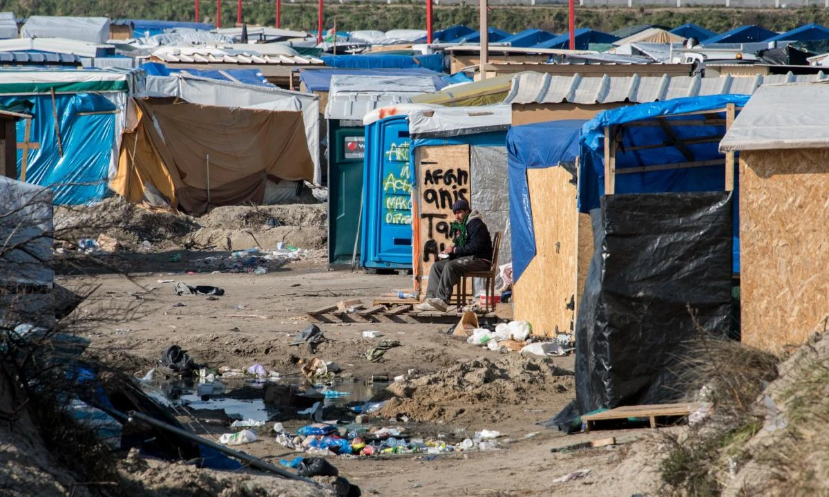 This file photo taken on March 16, 2016 shows a man sitting in the so-called “Jungle” migrant camp in Calais, northern France, during the end of the dismatling of the camp’s southern section. (AFP)