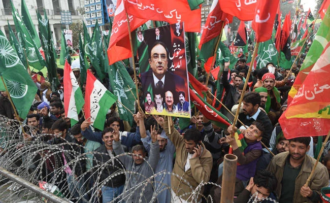 Supporters of Pakistan Awami Tehreek (PAT), Pakistan Peoples Party (PPP) and Pakistan Tehreek-i-Insaf (PTI) carry their party flags during an anti-government protest rally in Lahore on January 17, 2018. (AFP / ARIF ALI)