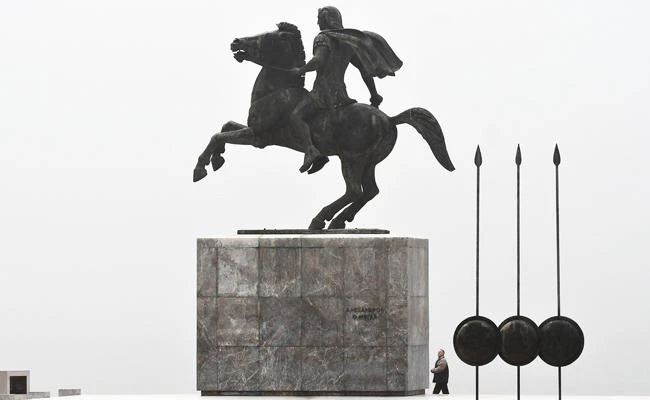 A man looks up at a statue of "Alexander the Great" on the waterfront of Thessaloniki on January 17, 2018. G(AFP / SAKIS MITROLIDIS)
