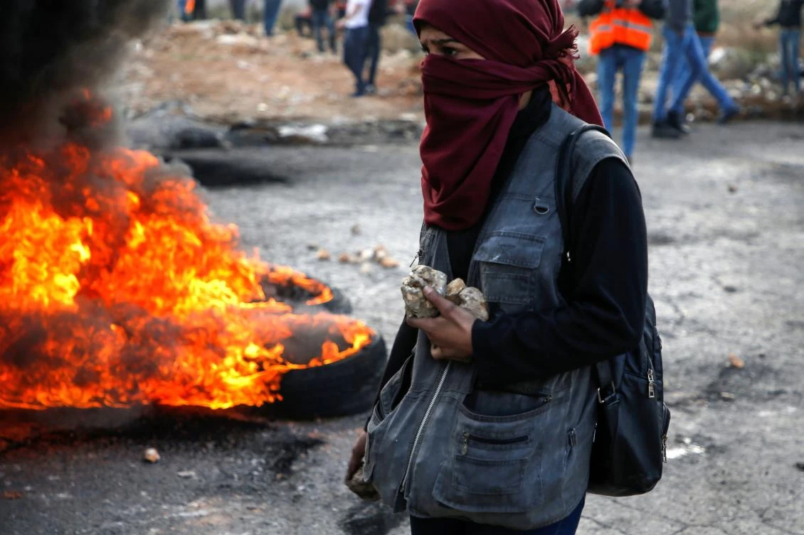 A Palestinian protester holds stones during clashes with Israeli forces north of Ramallah in the Israeli-occupied West Bank. (AFP)