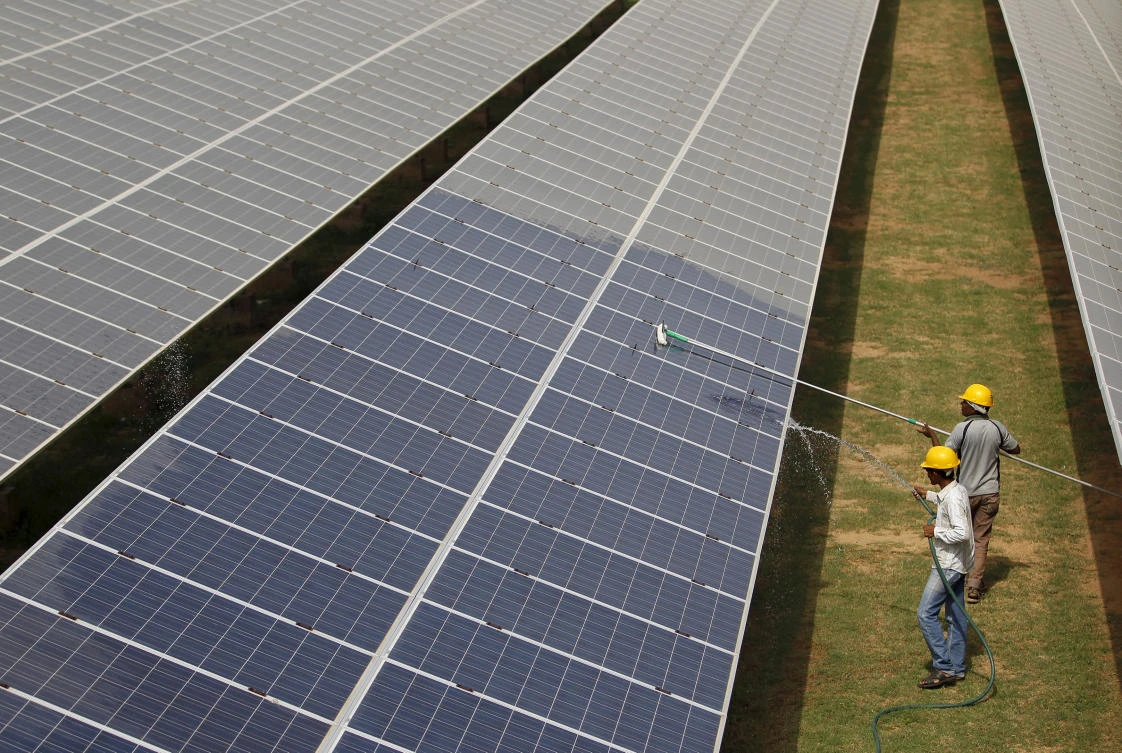 Above, workers clean photovoltaic panels inside a solar power plant in Gujarat in this 2015 photo. India, which receives twice as much sunshine as European nations, wants to make solar central to its renewable expansion. (Reuters)