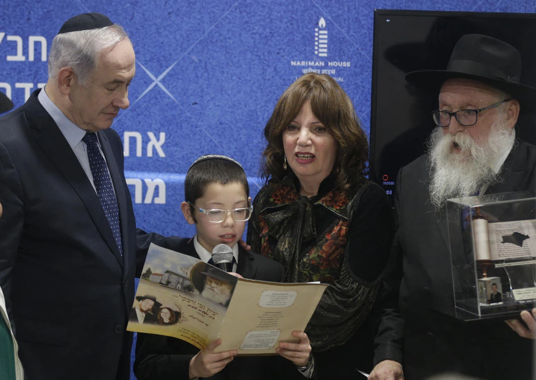 Benjamin Netanyahu, left, listens as Moshe Holtzberg, center, a young boy whose parents were killed during a 2008 terror attack reads a message during the unveiling of plans for a Living Memorial in Mumbai, India, Thursday, Jan. 18, 2018. (AP)