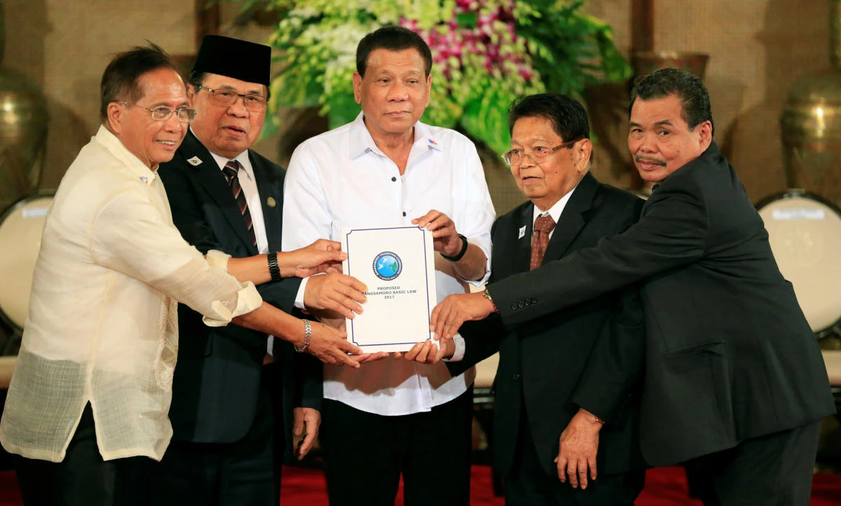 Philippine President Rodrigo Duterte, center, and from left: Jesus Dureza, Adviser for the Peace Process, Al Haj Murad Ebrahim, Moro Islamic Liberation Front (MILF) chairperson, Ghazali Jaafar, MILF vice-chairman, and Mohagher Iqbal, MILF peace panel chairman, hold a draft law of the Bangsamoro Basic Law during a ceremony at the Malacañan Palace in July 2017. (Reuters)