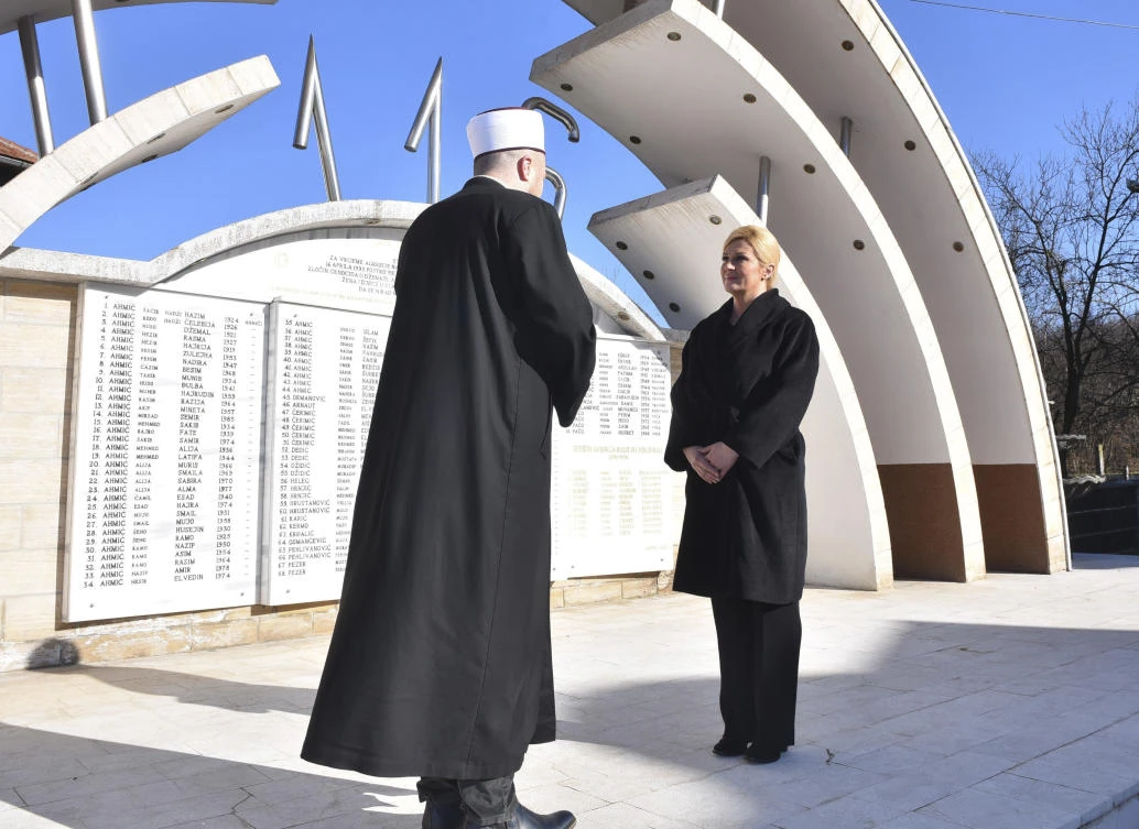 Croatia's president Kolinda Grabar-Kitarovic talks to local imam Mahir Husic as she pays tribute to 116 victims of Bosnian Croat forces raid in 1993, in the village of Ahmici, central Bosnia, Thursday, Jan. 18, 2018. (AP)