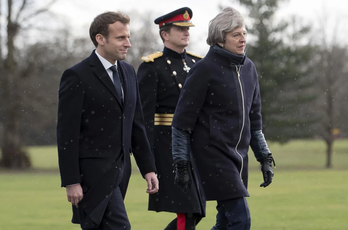 French President Emmanuel Macron (L) and Britain’s Prime Minister Theresa May arrive to review an honor guard at the Royal Military Academy Sandhurst, on January 18, 2018.(AFP)