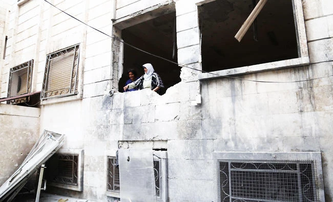 Syrians inspect damage at a psychiatric hospital after it was hit by mortar fire leaving at least one patient killed and over a dozen wounded, in the rebel-held town of Azaz in northern Syria on Friday. (AFP)
