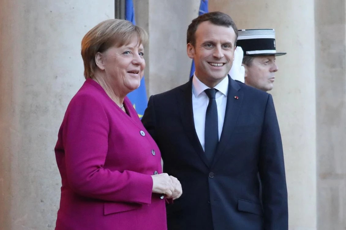 French president Emmanuel Macron (R) welcomes German Chancellor Angela Merkel at the Elysee Palace in Paris on January 19, 2018. (AFP)