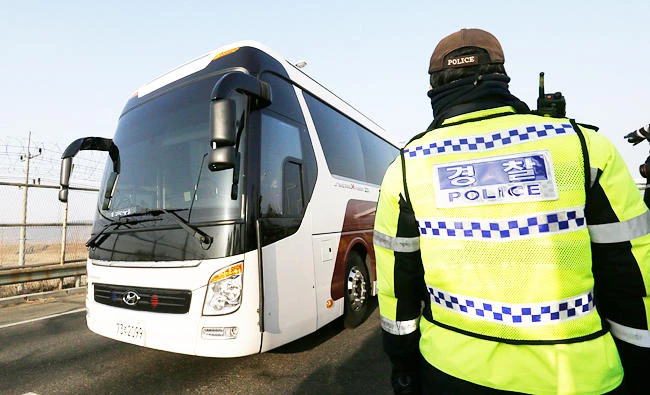 A bus carrying a North Korean delegation crosses the Unification Bridge as a South Korean policeman stands guard in Paju, South Korea, on Sunday. (AP)