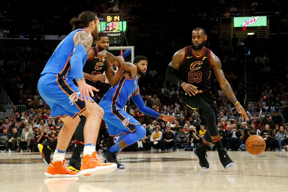 LeBron James #23 of the Cleveland Cavaliers drives the ball past Paul George #13 of the Oklahoma City Thunder and Steven Adams #12 of the Oklahoma City Thunder during the third quarter at Quicken Loans Arena on January 20, 2018 in Cleveland, Ohio. (AFP)