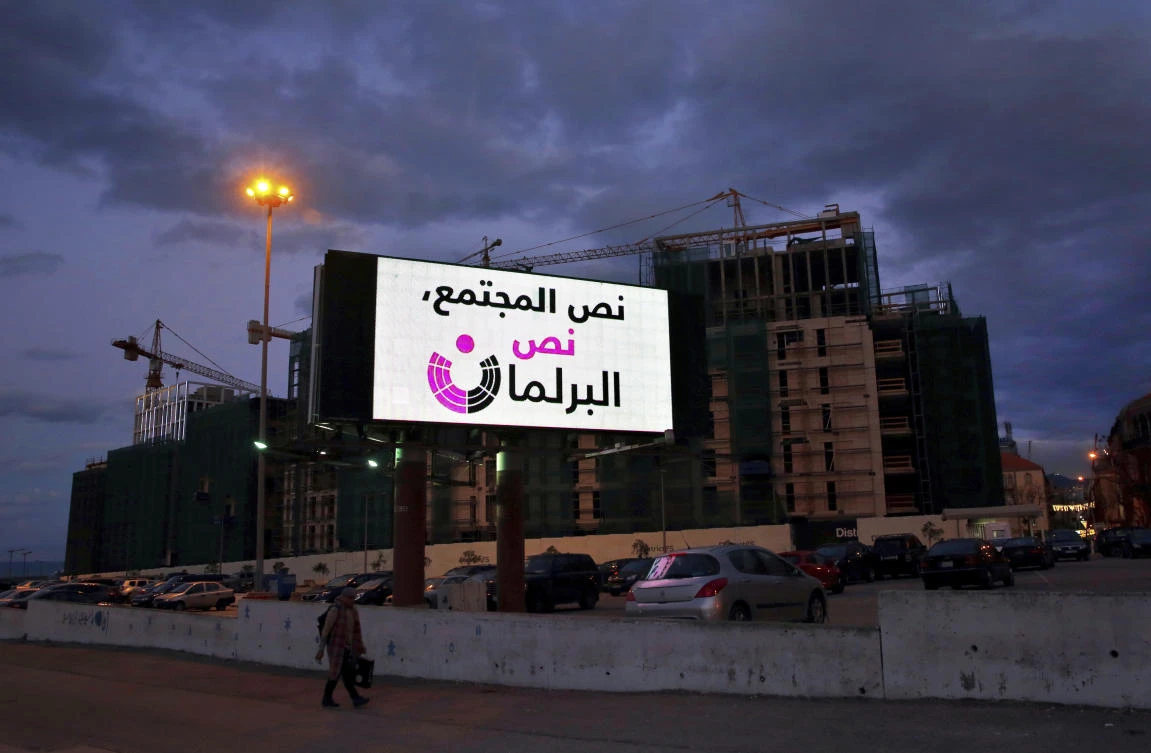 A man walks by a billboard encouraging more women candidates in upcoming parliament elections reading in Arabic “Half the society, half the parliament,” in downtown Beirut, Lebanon during a conference on women participation in politics. (AP)