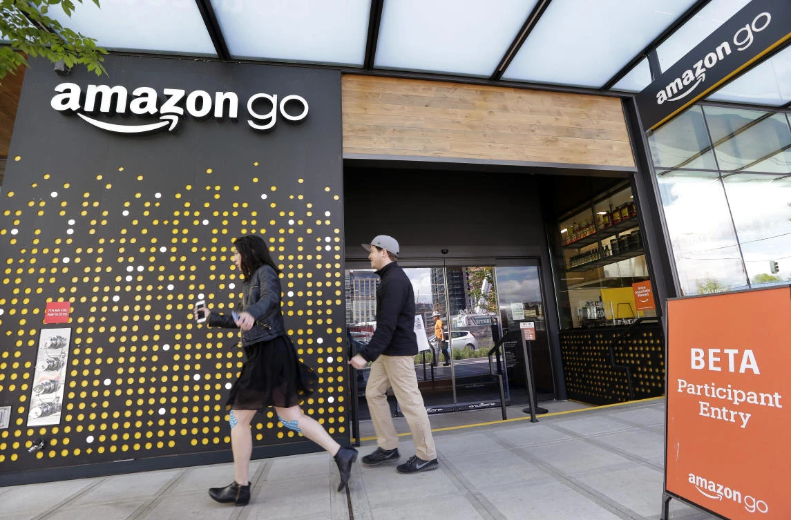 In this Thursday, April 27, 2017, file photo, people walk past an Amazon Go store in Seattle. Amazon Go shops are convenience stores that don't use cashiers or checkout lines, but use a tracking system that of sensors, algorithms, and cameras to determine what a customer has bought. (AP)