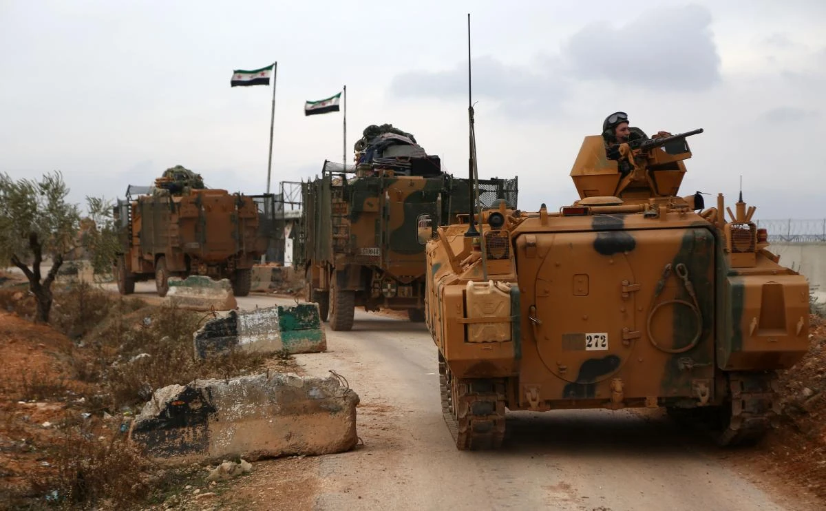 Turkish armoured personnel carriers (APCs) and infantry fighting vehicles (IFVs) are seen driving near the village of Yazi Bagh, about six kilometres from the Bab Al-Salamah border crossing between Syria and Turkey. (AFP)