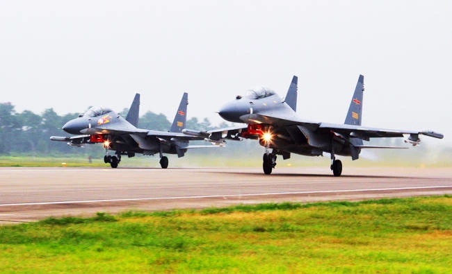In this undated file photo released on Aug. 6, 2016, by China's Xinhua News Agency, two Chinese SU-30 fighter jets take off from an unspecified location to fly a patrol over the South China Sea. (AP)