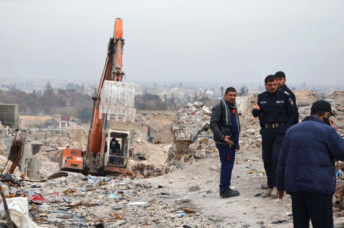 Iraqi men check a site in the city of Mosul where bodies of alleged Daesh militants remain on January 11, 2018. (AFP)