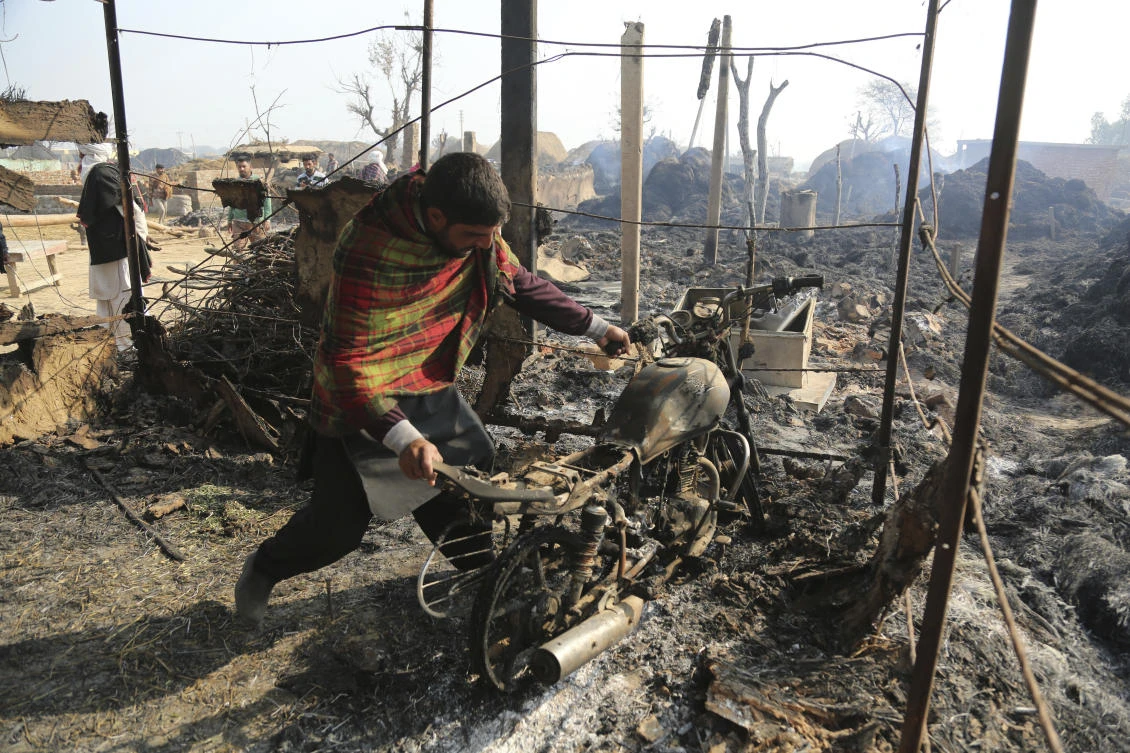 An Indian man pulls a motorbike from a building razed after a firing from the Pakistan side of the border into Jora in Ranbir Singh Pura district of Jammu and Kashmir. (AP)