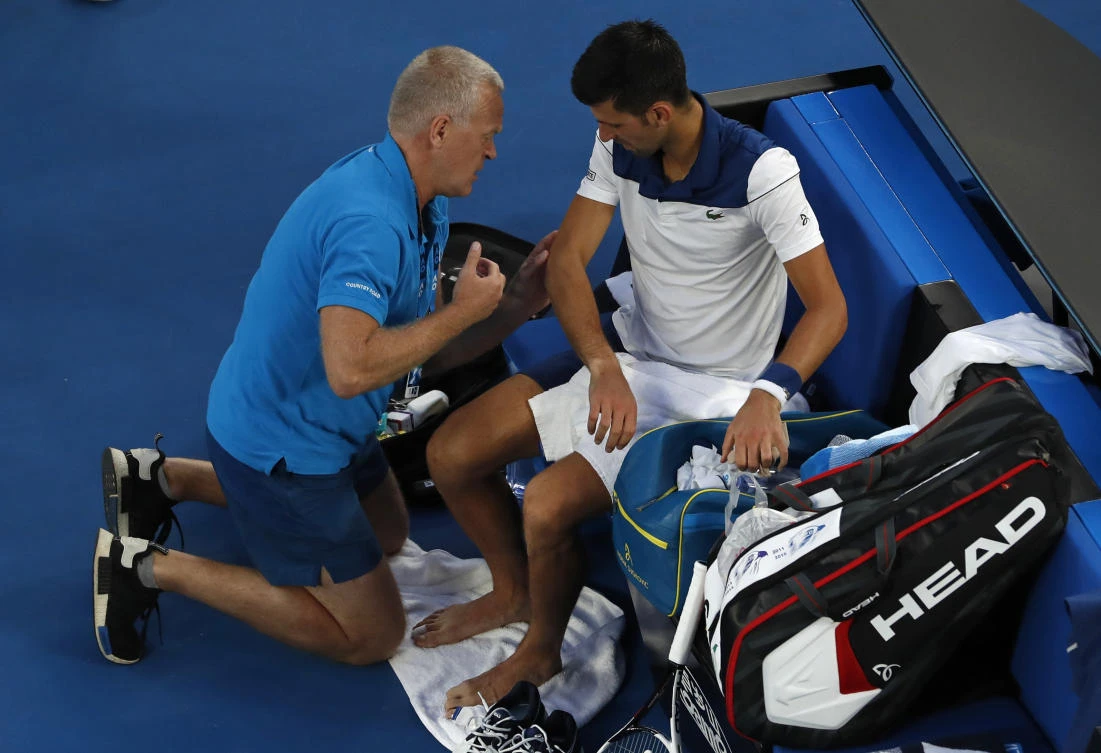 A trainer works on the elbow of Serbia's Novak Djokovic during his fourth round match against South Korea's Chung Hyeon at the Australian Open. (AP)