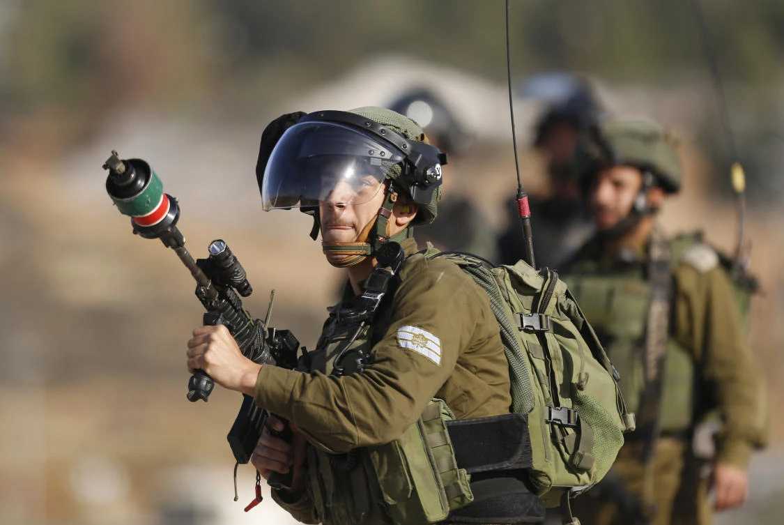 An Israeli soldier fires teargas toward Palestinians during clashes following a demonstration in support of Palestinian prisoners in Nabi Saleh near the West Bank city of Ramallah. (AP)