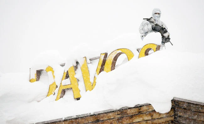 An armed security personnel wearing camouflage clothing stands on the rooftop of a Davos hotel as the 2018 World Economic Forum gets underway. (AFP)