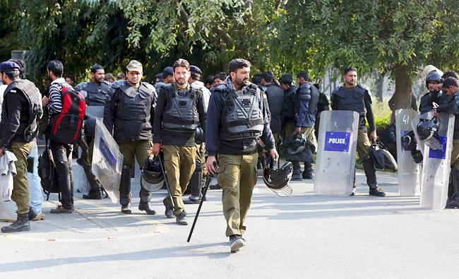 Pakistani police officers with riot gear stand guard at the University of Punjab following clashes between two student groups, in Lahore, Pakistan, on Monday. (AP)